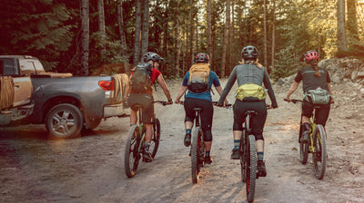 EVOC hip packs and hydration backpacks worn by women mountain bikers