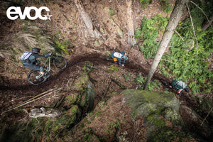 Mountain bikers in forest wearing EVOC backpacks