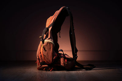 EVOC Explorer 30 liter backpack posed standing upright in a spotlight side view